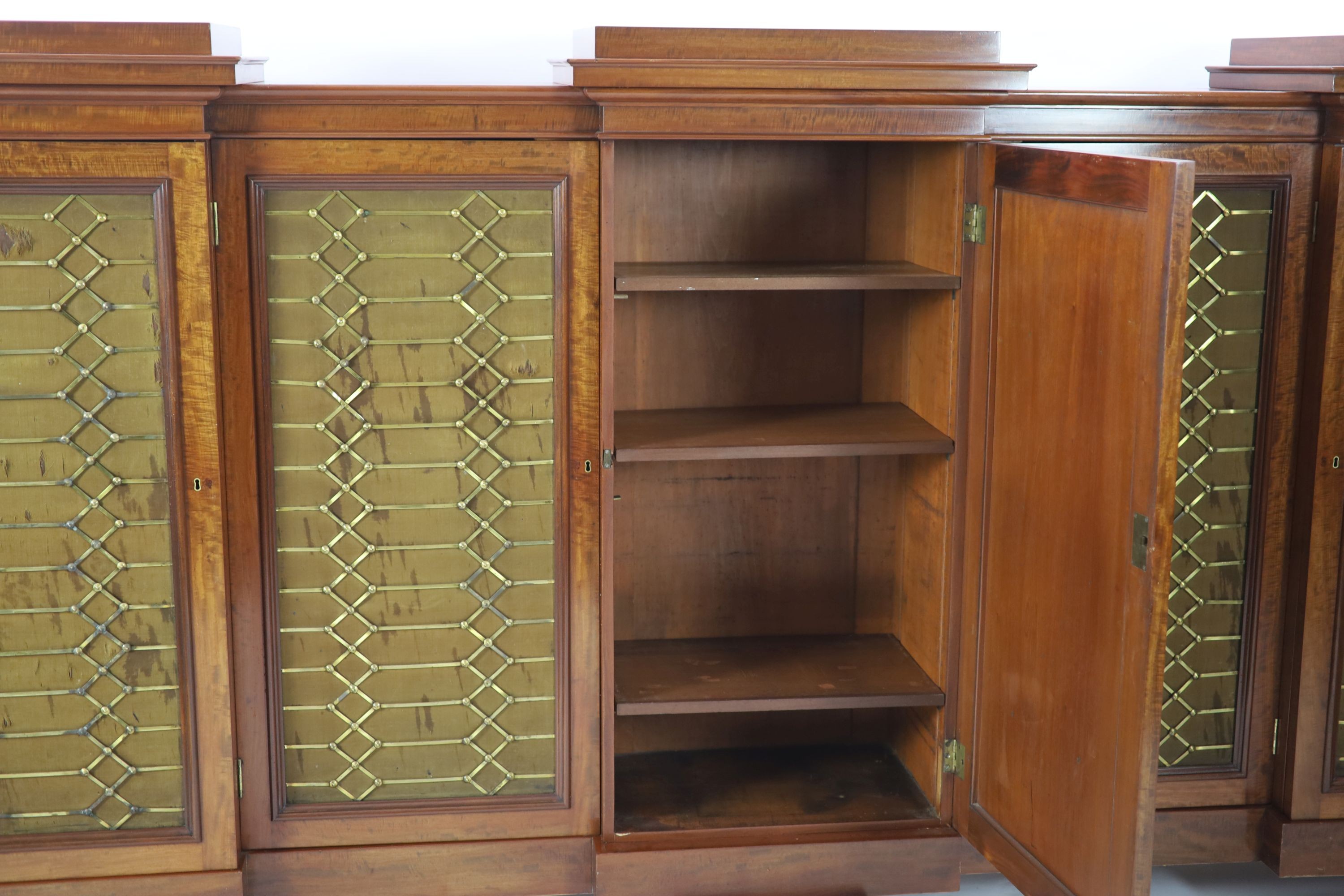 An early Victorian flame mahogany triple breakfront library cabinet, W.330cm D.51cm H.152cm